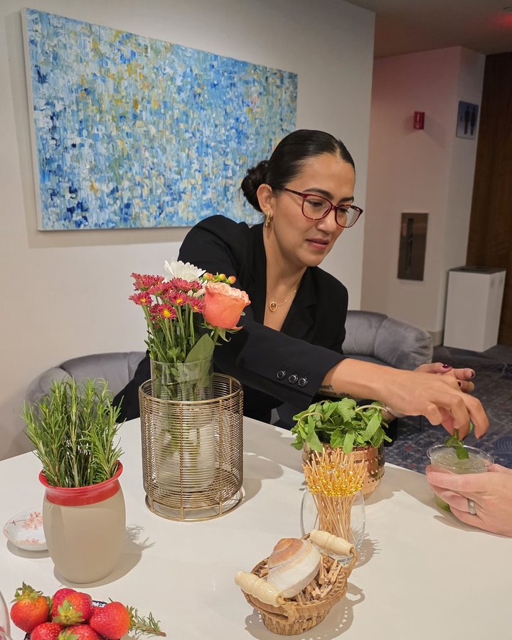 A Natural Mixologist team member garnishing a drink with fresh herbs at a private event